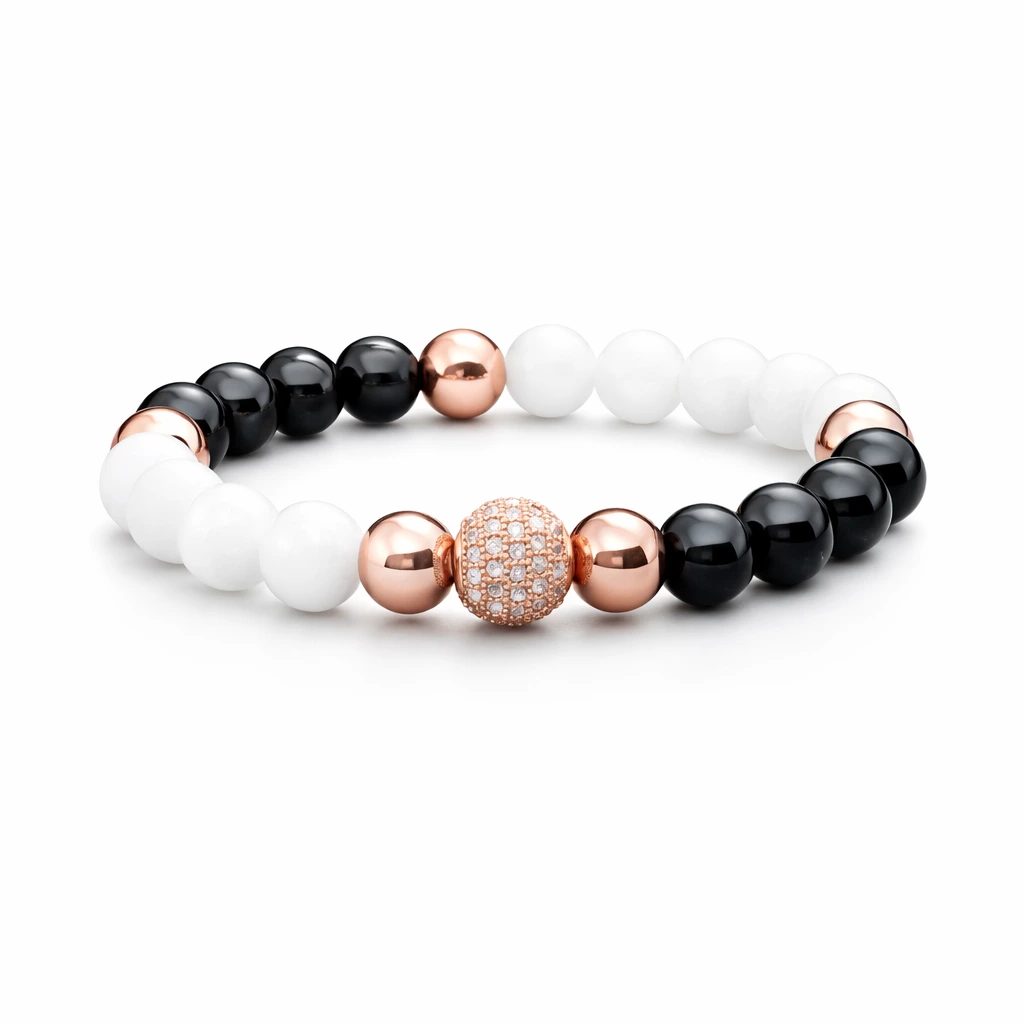 Fehér és fekete ásványgyöngyökből készült női ásvány karkötő rozéarany központi gyönggyel, fehér háttéren fotózva